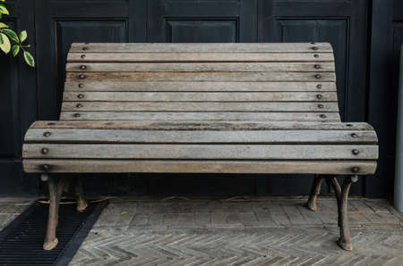 old wooden bench with black wooden wallの写真素材