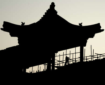 silhouette of traditional chinese building with workerの写真素材