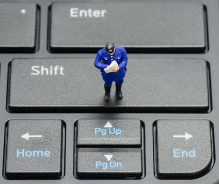 miniature policeman on the keyboard, computer security conceptの写真素材
