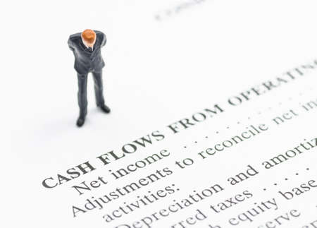 miniature business man stand on financial statementの写真素材