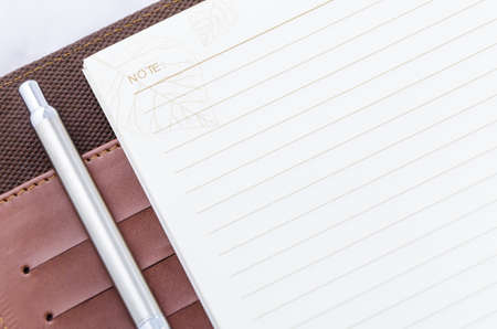 pen on the brown notebook