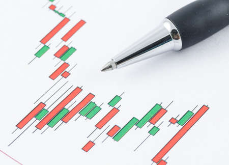 close up of candlestick stock chart with penの写真素材