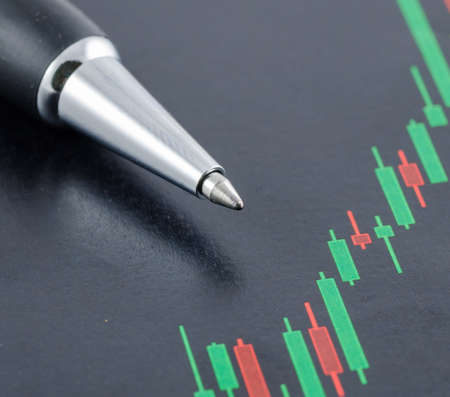 close up of candlestick stock chart with penの写真素材