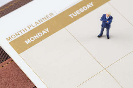 miniature businessman standing on the planner bookの写真素材