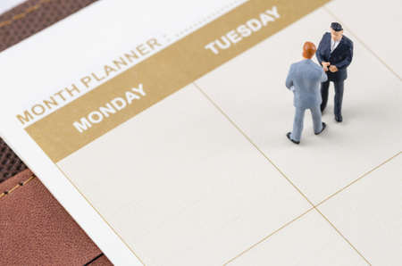 miniature businessman standing on the planner bookの写真素材
