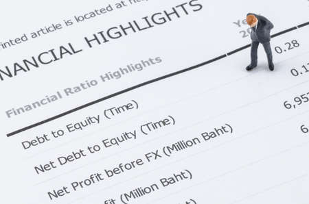 miniature businessman standing on the financial highlight in annual reportの写真素材