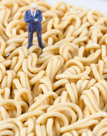 miniature businessman standing on the instant noodleの写真素材