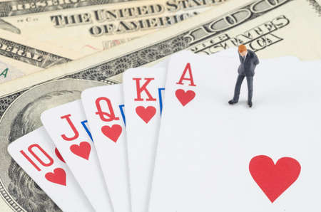 miniature businessman standing on the gamble card with US dollar