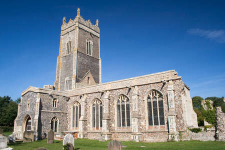 Church of St Andrew, Walberswick, Suffolk, England, against a blue skyの写真素材