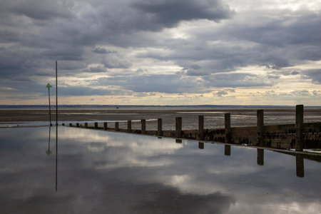 Moody reflections on Chalkwell Beach, near Southend-on-Sea, Essex, England, United Kingdomの写真素材
