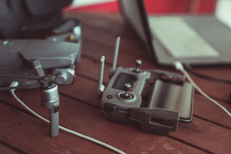 Drone quadcopter with a flight controller and notebook on the old wooden background.のeditorial素材