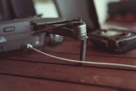 Drone quadcopter with a flight controller and notebook on the old wooden background.のeditorial素材