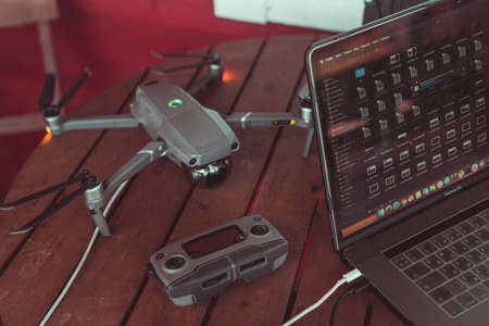 Drone quadcopter with a flight controller and notebook on the old wooden background.のeditorial素材