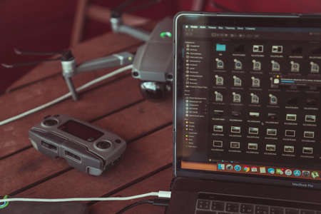 Drone quadcopter with a flight controller and notebook on the old wooden background.のeditorial素材