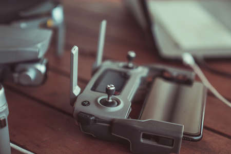 Drone quadcopter with a flight controller and notebook on the old wooden background.のeditorial素材