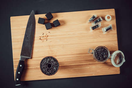 Hookah making on a wooden board and accessories. Hookah bowl, with tobacco stuffed into it.の写真素材