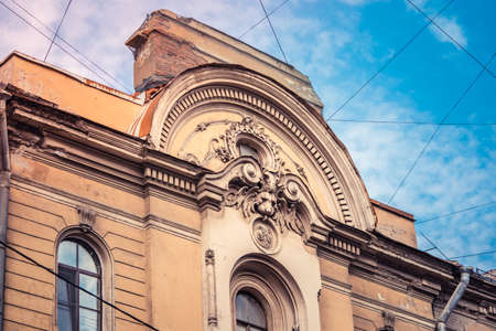 Stucco molding on the top part of a facade of the building against the sky with clouds in Saint-Petersburg, Russiaのeditorial素材