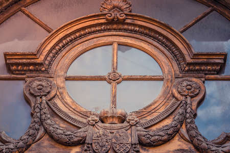 Round yellow window. Round wood window with a wooden crown in St.Petersburg, Russiaのeditorial素材