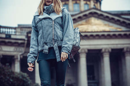 Traveler girl in warm clothes and a scarf turned to the camera on the background of Kazan Cathedral. Russia. Saint Petersburg.のeditorial素材