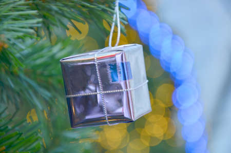 Christmas background with a red ornament, golden gift box, berries and fir in snowの写真素材