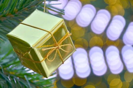 Christmas background with a red ornament, golden gift box, berries and fir in snowの写真素材