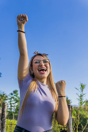 Women Day, March 8, empowered and self-confident woman. Woman expressing leadership and character. Woman happy in nature. Girl with glasses. Girl raising her hands.の写真素材