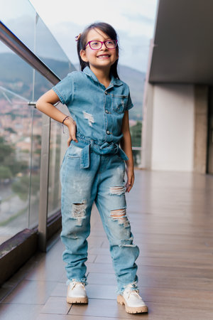 Latin girl with glasses posing on a high floor very happy. Childhood, vacations and fun. Children's day. Model.の写真素材