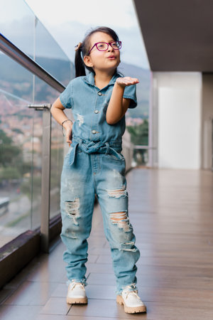 Latin girl with glasses posing on a high floor very happy. Childhood, vacations and fun. Children's day. Model.の写真素材