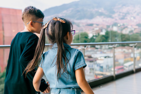 Latino children playing while sitting on a high floor very happy. Siblings, vacations and family. Children's day.の写真素材