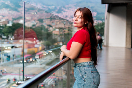 Beautiful latina woman in red blouse modeling. Empowered, self-confident, serene and calm woman. Self-esteem and appearance.の写真素材
