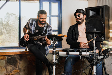 Friends rehearsing at home, guitar and drums. Music band. International music day.の写真素材