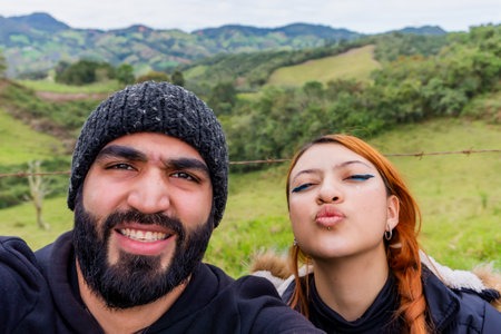 Adult Latino man with his beautiful wife taking a selfie and smiling in the mountains near Medellin,...