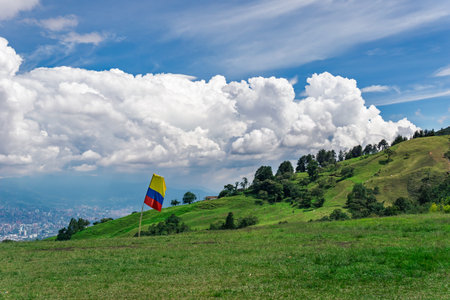 Colombia's national flag flying on a mountain in the outskirts of Medellinの写真素材