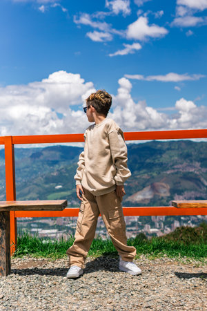 Latino boy looking sideways in a scenic outdoor mountain settingの写真素材