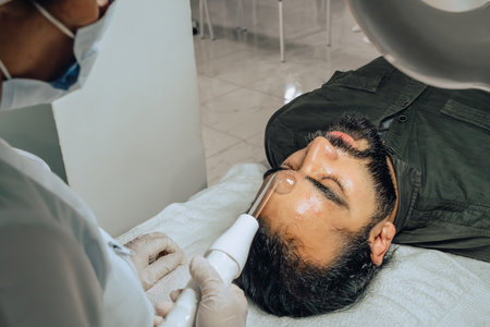 Photo of a bearded mixed-race Colombian man at a beauty spa where a facial cleansing is performed...