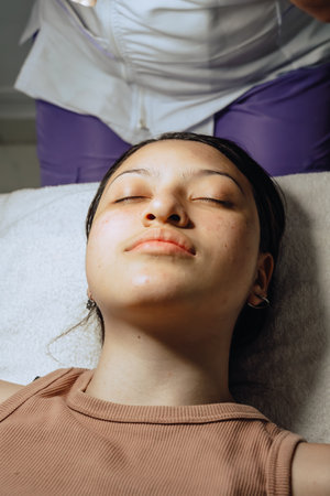 Photo of a young Colombian mestiza at a beauty spa where she is waiting for a facial cleansing to begin.の写真素材