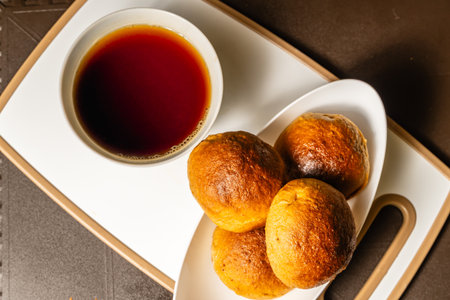 horizontal zenithal shot of traditional artisan whole wheat mogolla bread next to a cup of coffee in a healthy vegetarian restaurant in Colombia.の写真素材