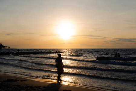 Silhouettes of people in the sea at sunset on beach near CoveÃ±as, Colombian Caribbean.の写真素材