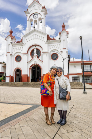 Colombian mother and daughter posing in front of Parroquia Nuestra SeÃ±ora de la Candelaria in Guarne town parkの写真素材