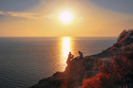 Climbing on the rocky coast of the Black Sea at sunset. Cape Fiolent, Crimean peninsulaの写真素材