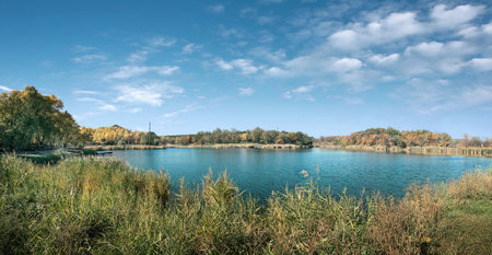 Autumn landscape with lake and blue sky with clouds. Panoramaの写真素材