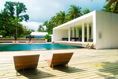 Tropical swimming pool with sunbeds in Thailand