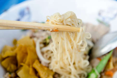 Noodles spicy in bowl and chopsticks の写真素材