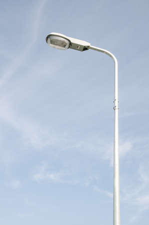 Street light with halogen lamp against blue skyの写真素材