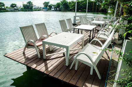 white chairs and table on coast of a reservoirの写真素材