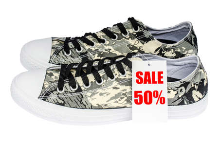 Sale sign made of paper promoting large discounts pattern soldier sneakers isolated on white backgroundの写真素材