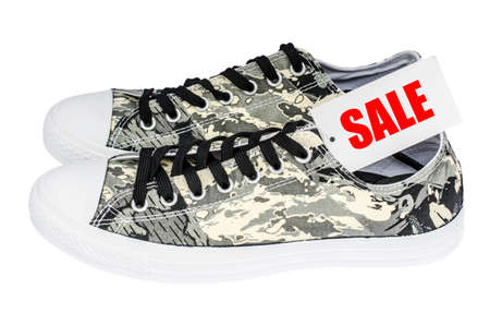 Sale sign made of paper promoting large discounts pattern soldier sneakers isolated on white backgroundの写真素材