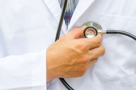 Close up male doctor is hand checking his own heartの写真素材