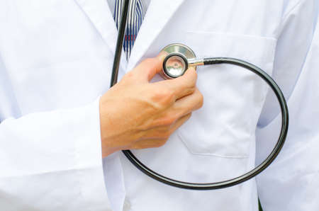 Close up male doctor is hand checking his own heartの写真素材