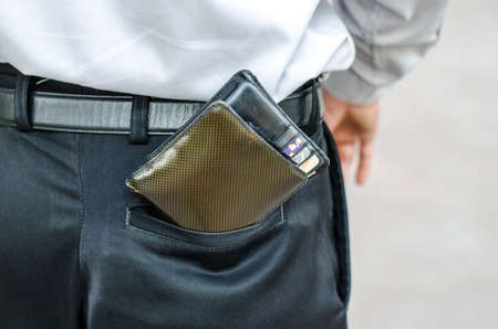 Closeup. Careless man with wallet falling back pocket. Risk of theft.の写真素材